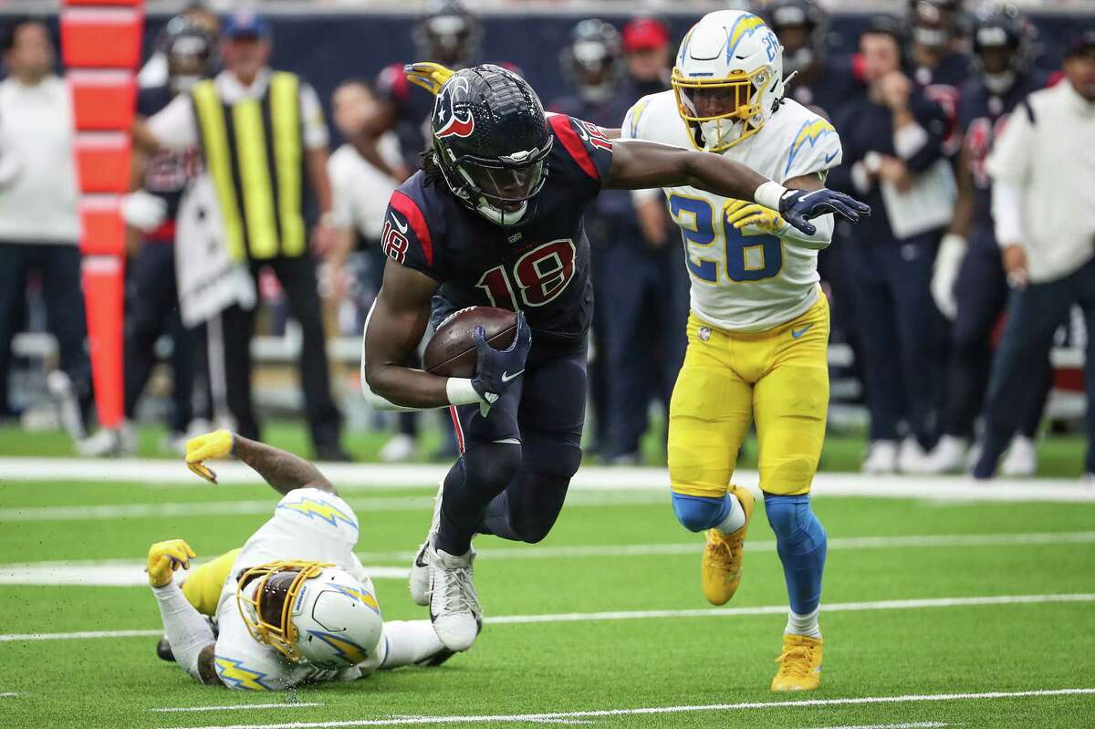 Houston Texans wide receiver Chris Conley (18) makes a catch against Los Angeles Chargers cornerback Davontae Harris (28) during the third quarter of an NFL football game Sunday, Dec. 26, 2021 in Houston.
