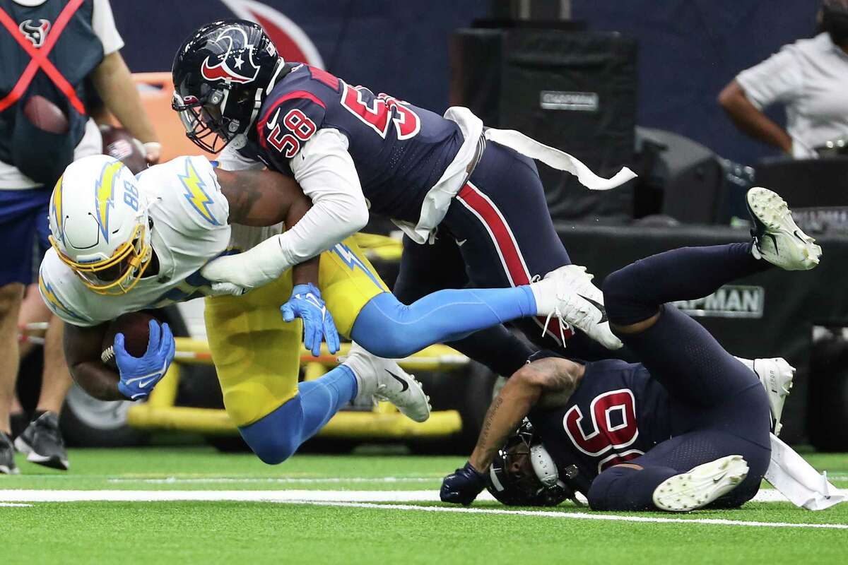 Houston Texans middle linebacker Christian Kirksey (58) stops Los Angeles Chargers tight end Tre' McKitty (88) during the third quarter of an NFL football game Sunday, Dec. 26, 2021 in Houston.