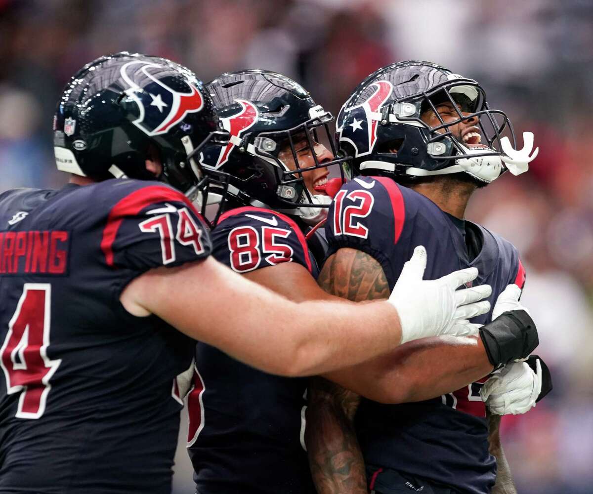 Houston Texans wide receiver Nico Collins (12) celebrates with tight end Pharaoh Brown (85) and guard Max Scharping (74) after scoring a 13-yard receiving touchdown against the Los Angeles Chargers during the fourth quarter of an NFL game at NRG Stadium on Sunday, Dec. 26, 2021, in Houston.