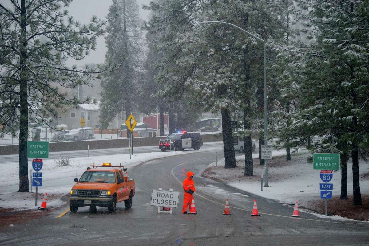 A Caltrans maintenance worker blocks an on-ramp to Interstate 80 at Colfax (Placer County), closed during dangerous snow conditions.