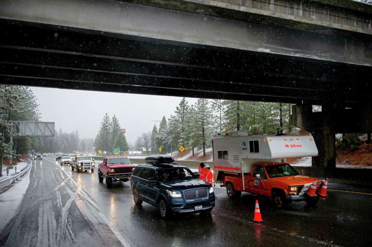 Caltrans maintenance workers Austin George and Austin Gandy direct traffic off Interstate 80 at Colfax after storm conditions forced closure of the freeway during the holiday weekend.