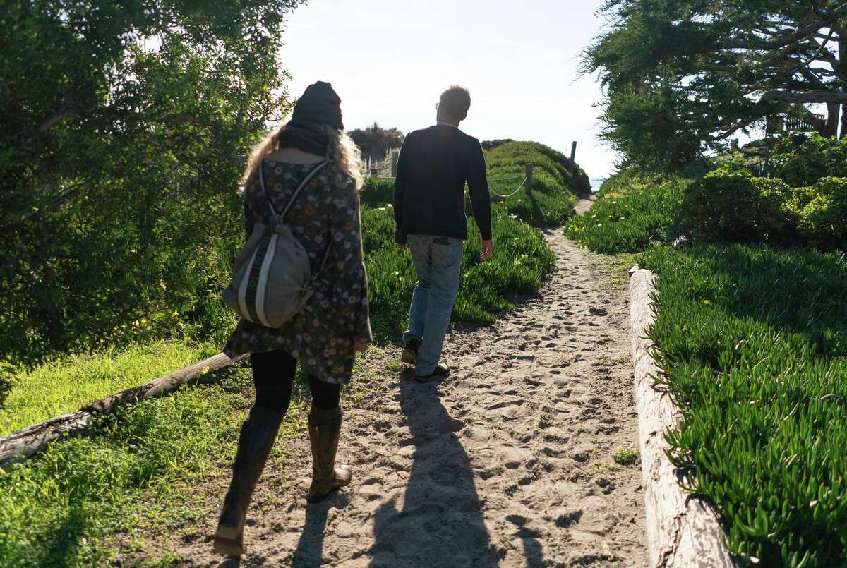 Toby Bisson and Mary Greenwood walk to Stinson Beach through a neighborhood path. Sea level rise, as well as 100-year storms, are threatening the way of life for residents of this historic community.