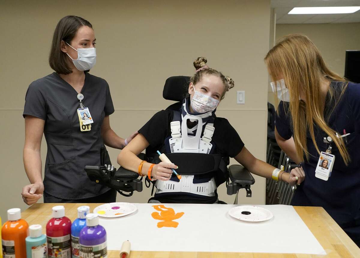 Ashlee Sand, occupational therapist, left, and Mel Mitchell, physical therapist, right, work with Makayla Noble, at TIRR Memorial Hermann, 1333 Moursund St., Wednesday, Nov. 10, 2021 in Houston.