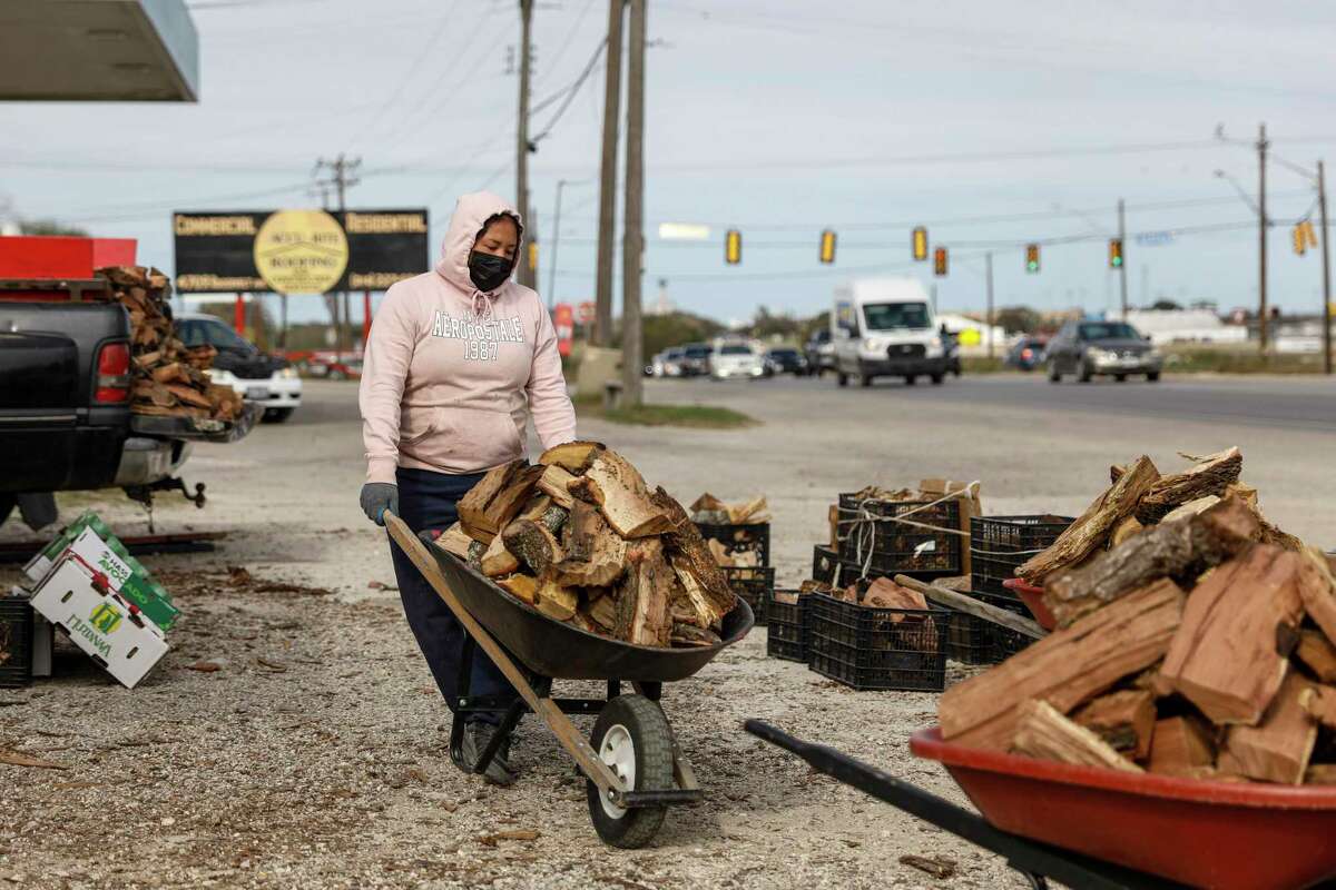 Alyssa Villarreal prepares to offload a wheelbarrow of wood to a customer at her street vending stand near the corner of East Ashley Road and Roosevelt Avenue on the South Side on Dec. 11, 2021. The 18-year-old has been working for her family’s street vending business since she was 10.