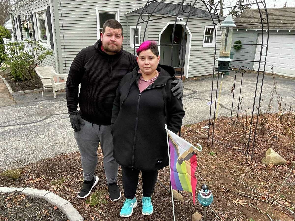 Joe and Liz Bossoli are pictured outside their Hamden home with their Pride Progress Flag, which was vandalized twice in just a few days.