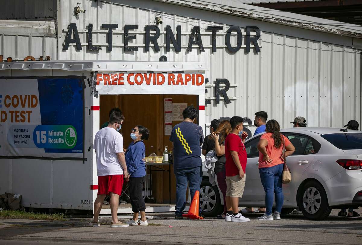 People wait in line at a Covid-19 testing kiosk in a parking lot of a La Guerrero meat market on N. Shepherd Drive, Monday, Dec. 27, 2021, in Houston.