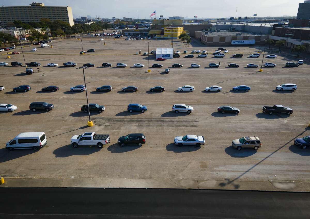 Approximately 100 cars wait in line at a free, drive-thru Covid-19 testing site run by United Memorial Medical Center, Monday, Dec. 27, 2021, at PlazAmericas shopping mall in Houston.