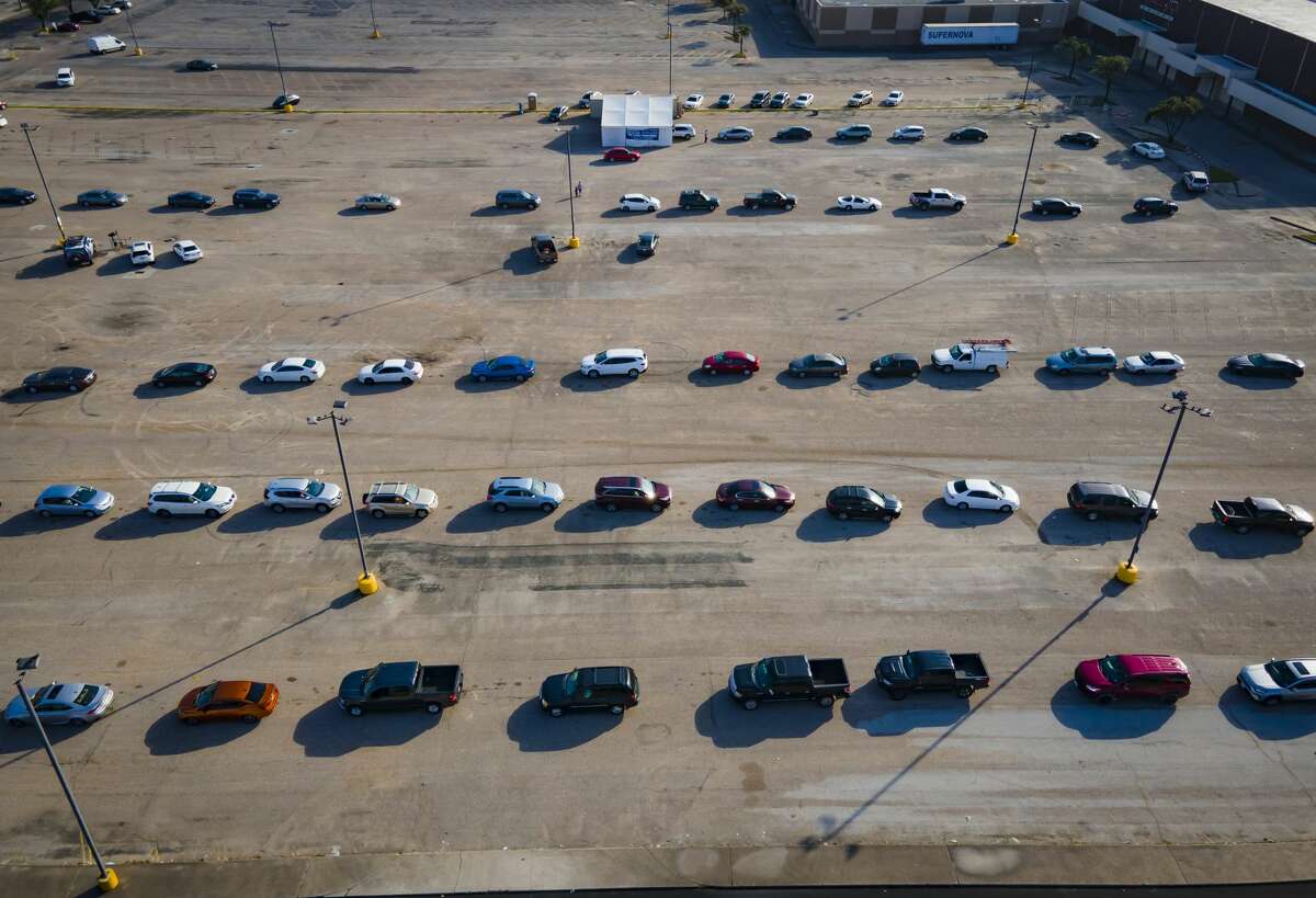 Approximately 100 cars wait in line at a free, drive-thru Covid-19 testing site run by United Memorial Medical Center, Monday, Dec. 27, 2021, at PlazAmericas shopping mall in Houston.