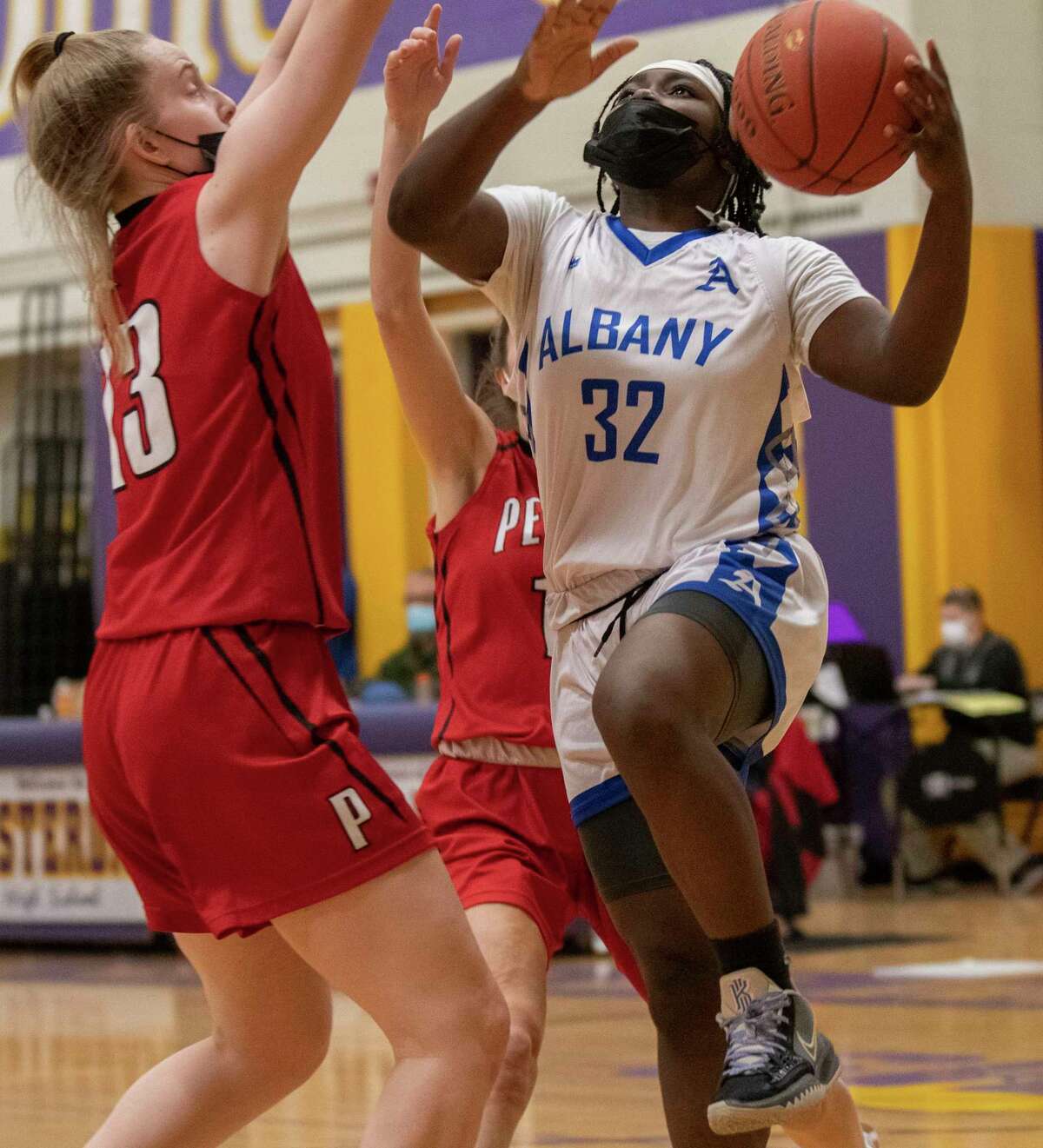 Albany's Azera Gates is guarded by Penfield’s Jackie Funk as she drives to the hoop during a basketball game on Monday, Dec. 27, 2021 in Amsterdam, N.Y.