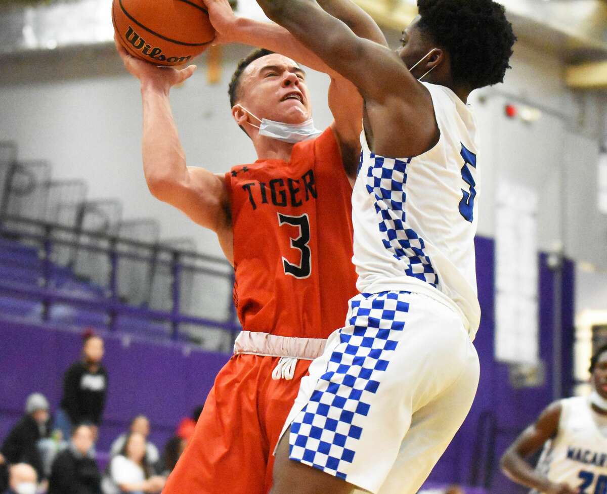 Edwardsville's Bryce Spiller is fouled going up for a shot in the fourth quarter against Decatur MacArthur on Monday in Collinsville.