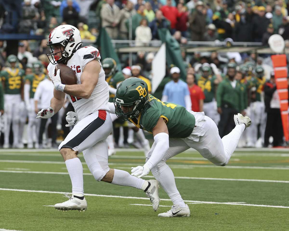 Texas Tech wide receiver McLane Mannix catches a pass for a touchdown against Baylor safety Jalen Pitre in the second half of an NCAA college football game Saturday, Nov. 27, 2021, in Waco, Texas.