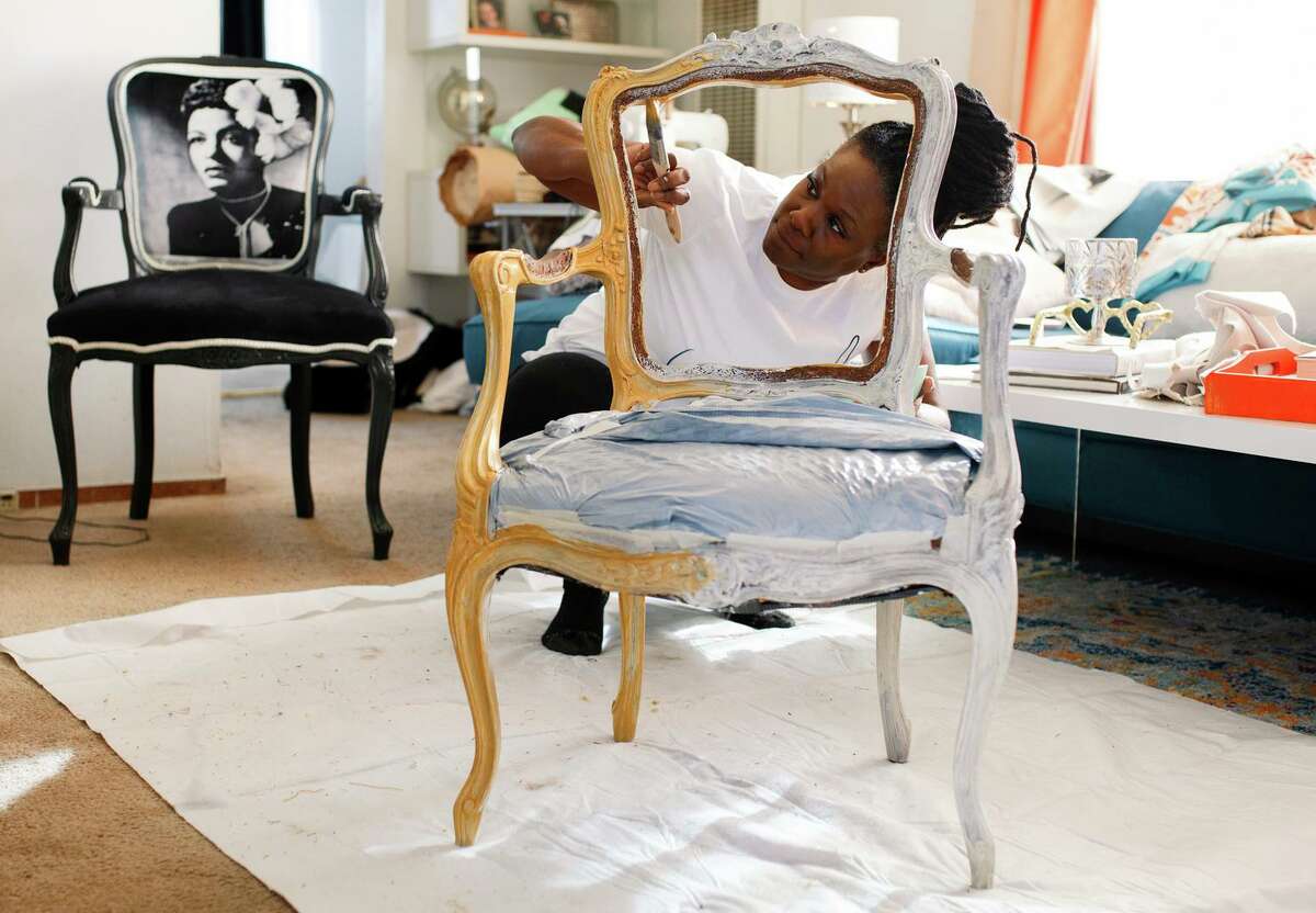 La Kesha Wash, founder of Meticulous Designs, paints a chair that will feature an image of Lena Horne while working at her home office in Alameda.
