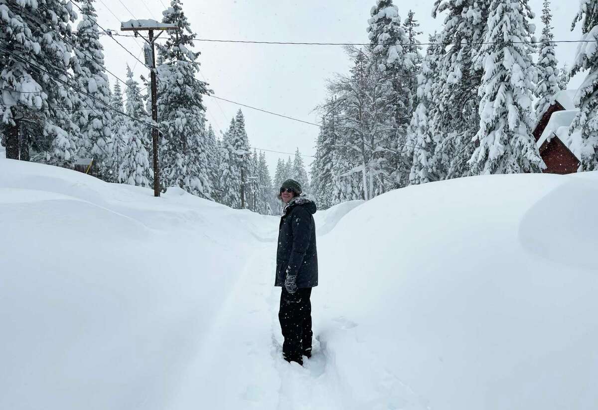 迈克·法雷尔(Mike Farrell)在加利福尼亚州特拉基(Truckee)的Tahoe Donner社区走过大雪。大雪淹没了Tahoe和Sierra的大部分地区，堵塞了道路，并中断了太平洋天然气和电力公司数万名客户的电力供应。