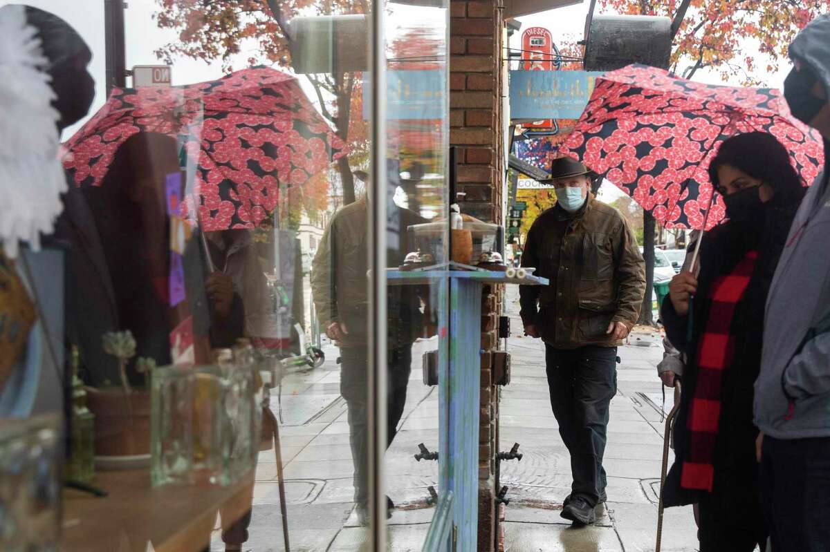 Customers wear masks while ordering from The Chocolate Dragon along College Avenue in Oakland, Calif. Thursday, Dec. 23, 2021.