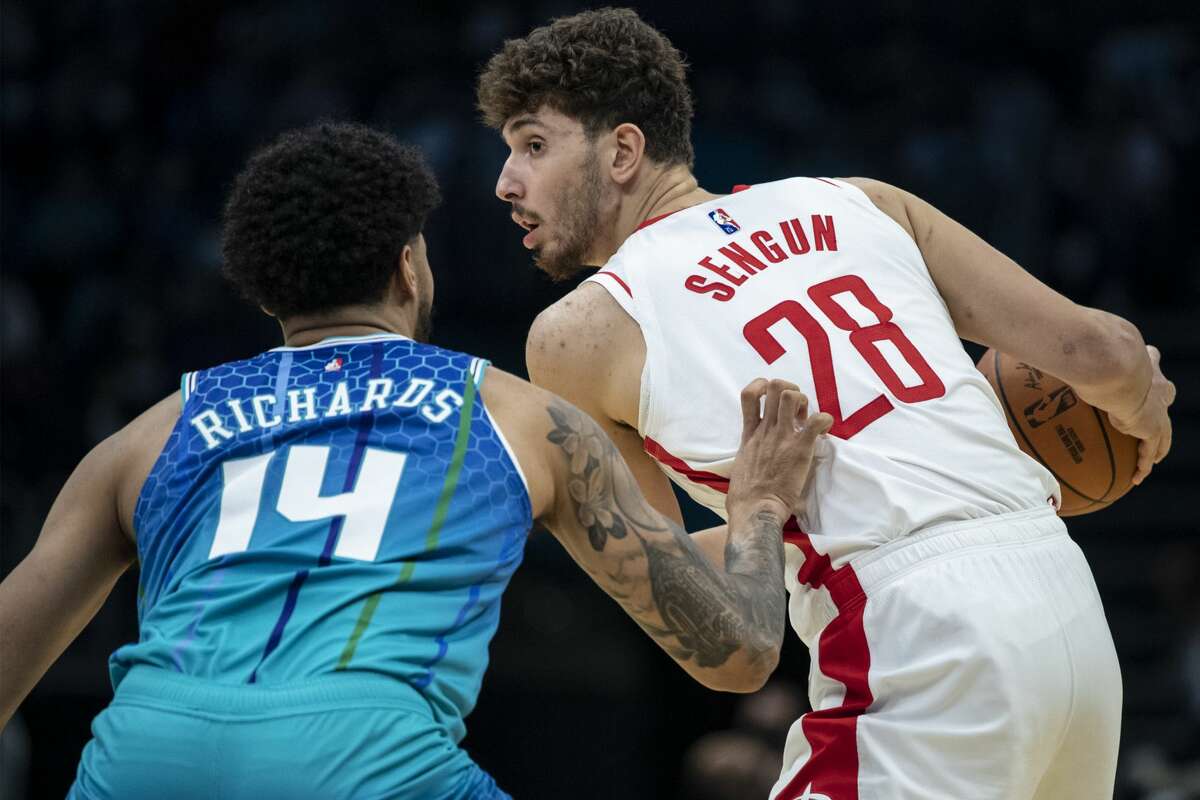 Houston Rockets center Alperen Sengun (28) looks to pass the ball while being defended by Charlotte Hornets center Nick Richards (14) during the second half of an NBA basketball game Monday, Dec. 27, 2021, in Charlotte, N.C. (AP Photo/Matt Kelley)
