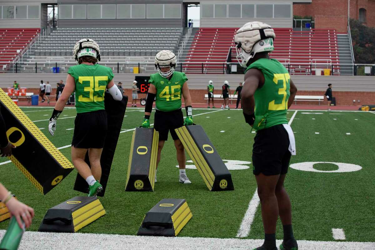Oregon Ducks players set up pads for skills during practice at Trinity University ahead of the Alamo Bowl where they will face off against Oklahoma.