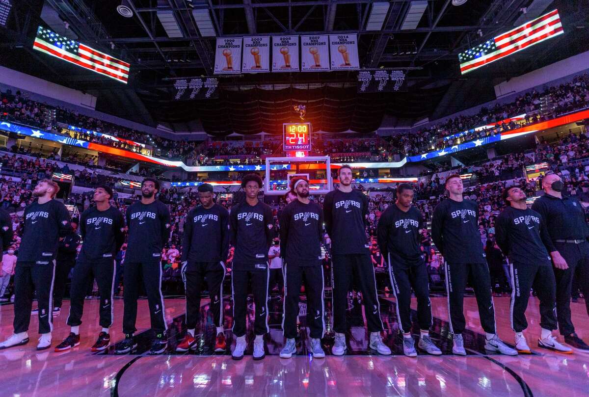 The Spurs stand Monday. Dec. 27, 2021 at the AT&T Center for the national anthem before the start of the Spurs?• game against the Utah Jazz. Utah won 110-104.