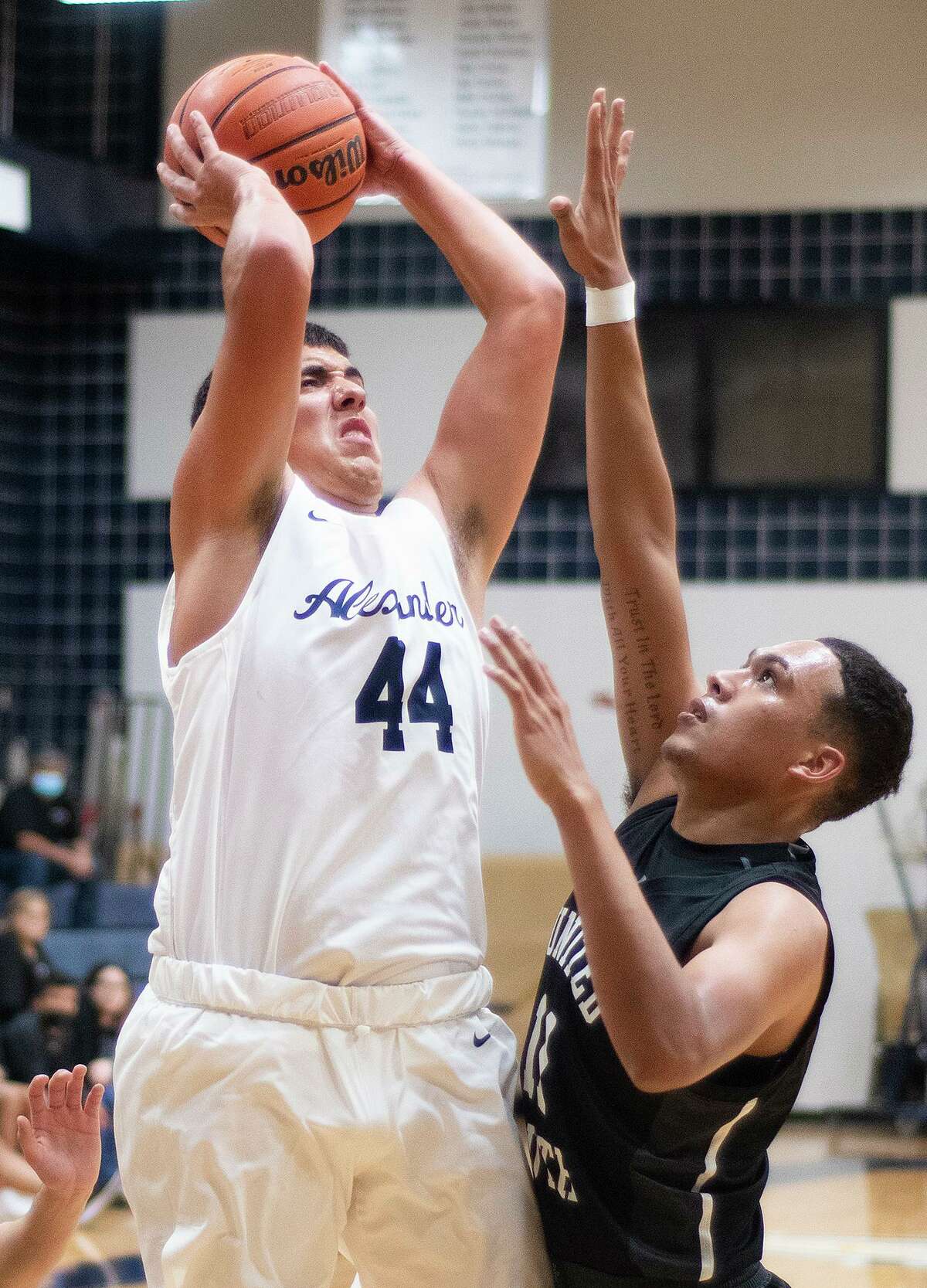 Alexander High School Lalo Uribe takes a jump shot as United South High School Oscar Medrano reaches for the block, Tuesday, Dec. 21, 2021, at Alexander High School.