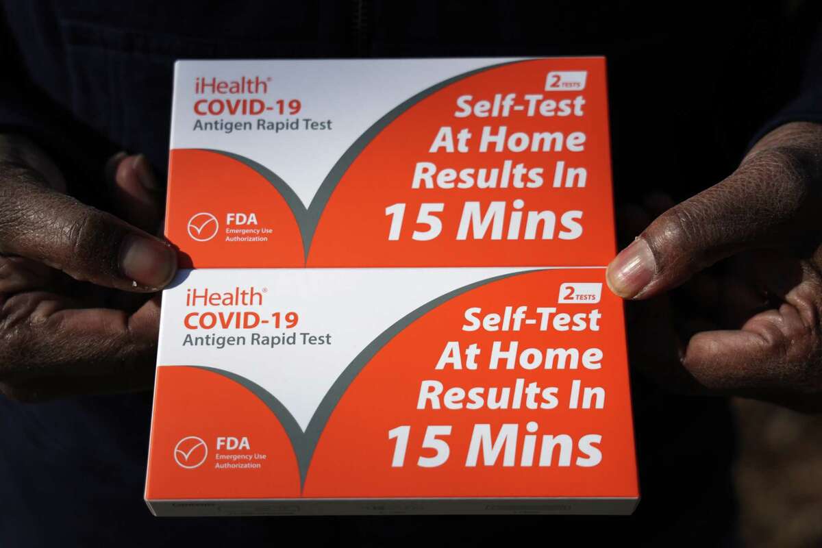 WASHINGTON, DC - DECEMBER 23: A man shows the free COVID test kits he has received outside Petworth Library on December 23, 2021 in Washington, DC. Connecticut municipalities, including Trumbull, are distributing free test kits to local residents prior to the holidays as COVID case numbers have surged to a new high. (Photo by Alex Wong/Getty Images)