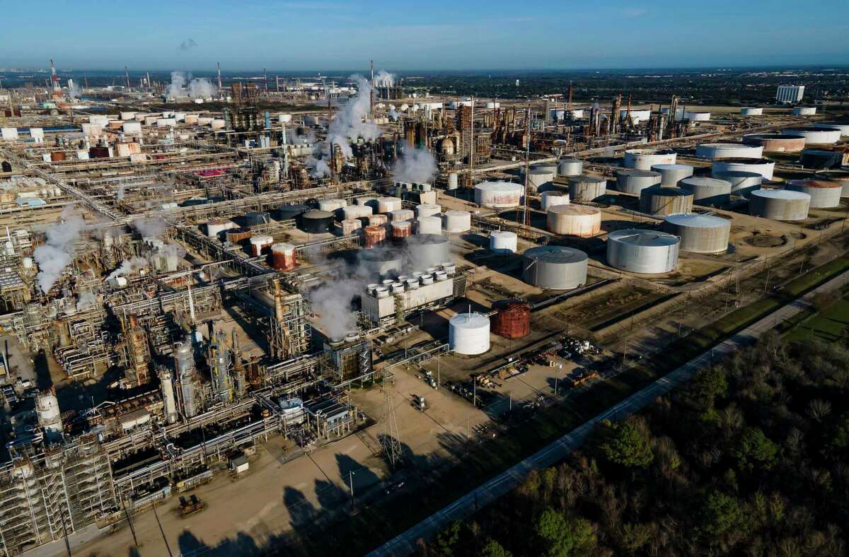 Smoke still fills the air at ExxonMobil’s refinery on Thursday, Dec. 23, 2021 in Baytown, Texas. Crews have extinguished a large fire at a Houston-area refinery that left four people injured. (Mark Mulligan/Houston Chronicle via AP)