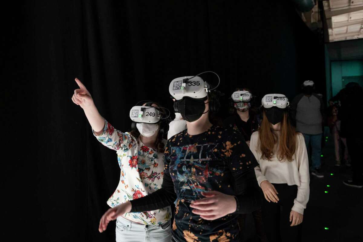 A group goes through the “onboarding” process before entering the virtual reality portion of The Infinite Tuesday, Dec. 21, 2021, at Silver Street Studios in Sawyer Yards in Houston.