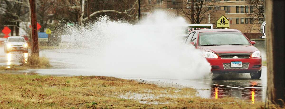 John Badman|The Telegraph A car splashes through standing water in the 200 block of Edwardsville Road in Wood River Tuesday.