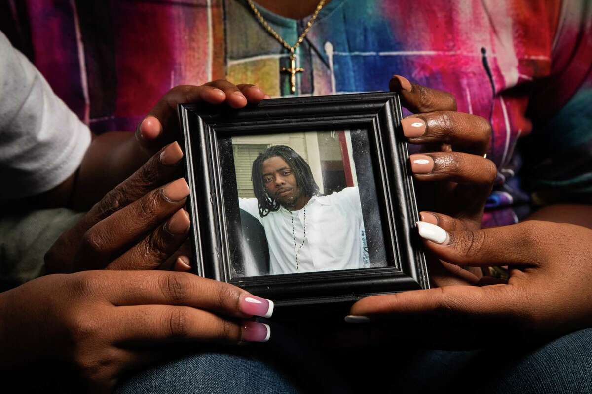 Anaya Barnes, 21, Ashtian Harris, 3, Janice Barnes, 52, and Aledra Barnes, 25, hold a photo of Ashtian Barnes, Monday, Dec. 13, 2021, in Houston. Ashtian Barnes was fatally shot by a Harris County Precinct 5 deputy constable after an attempted traffic stop for unpaid tolls on Beltway 8 on April 2016.