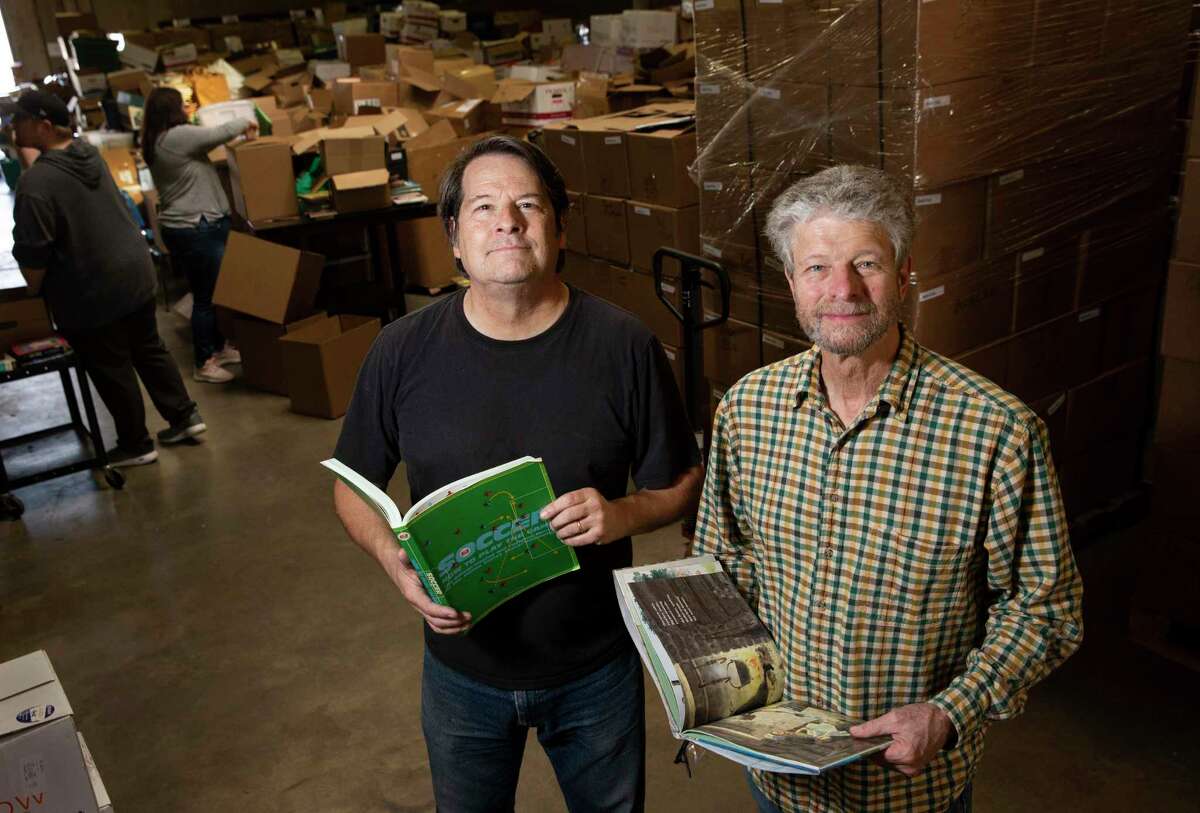 Books for Development founder and president Mark Cotham, left, and warehouse manager Todd Malejan are on a mission to help.