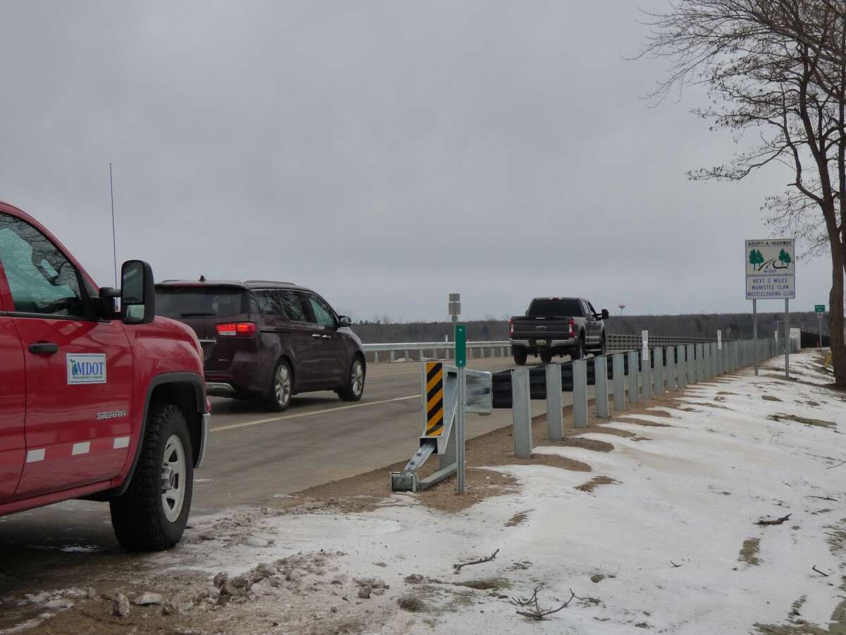 The first vehicles pass over the newly reopened M-55 bridge on Dec. 28 in Manistee Township.