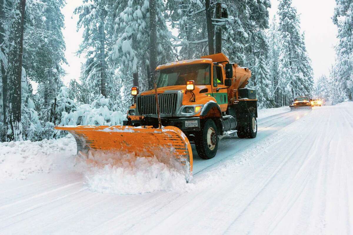 A snowplow clears snow along Highway 88 through the Sierra Nevada.