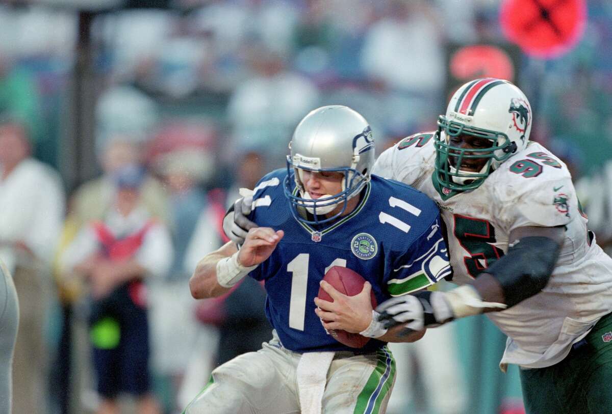 3 Sep 2000: Brock Huard #11 of the Seattle Seahawks moves with the ball as Tim Bowens #95 tries to tackle him during the game against the Miami Dolphins at the Pro Players Stadium in Miami, Florida. The Dolphins defeated the Seahawks 23-0.