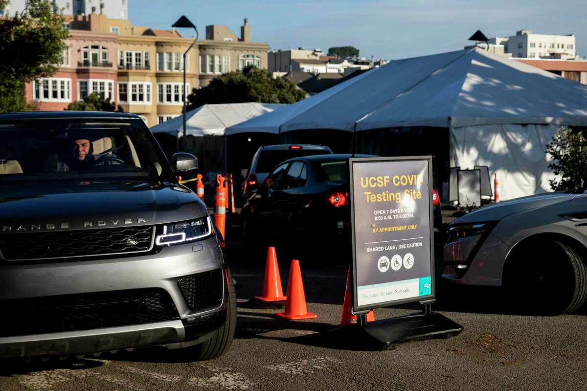 Cars line up to receive a drive-thru COVID-19 test at a testing site at UCSF?•s Laurel Heights Campus in San Francisco, Calif. Tuesday, Dec. 21, 2021. Local health officials are yet again beefing up staff and capacity at testing and vaccine sites ahead of an omicron wave.