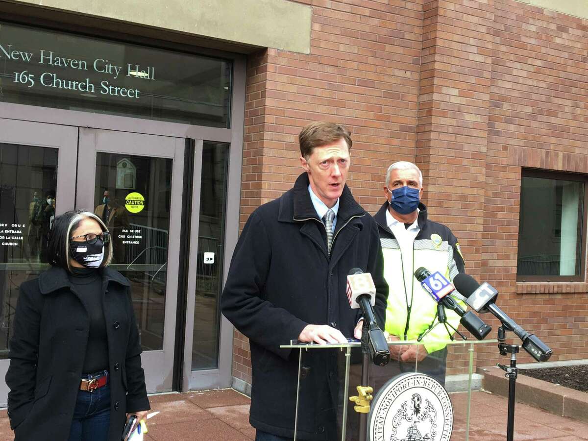 New Haven Mayor Justin Elicker, center, speaks during a press conference at City Hall earlier this week. At another press conference Wednesday, he debunked rumors that the city’s schools are going remote in January.