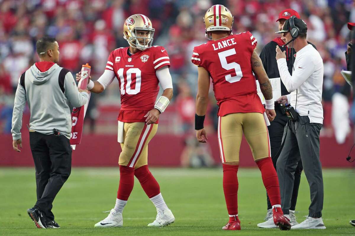 San Francisco 49ers' Jimmy Garoppolo confers with head coach Kyle Shanahan as Trey Lance looks on in 4th quarter of 34-26 win over Minnesota Vikings during NFL game at Levi's Stadium in Santa Clara, Calif., on Sunday, November 28, 2021.