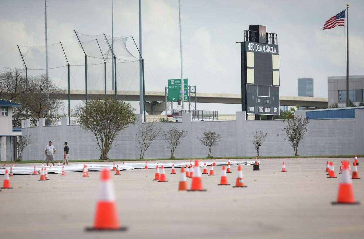 Workers set up a COVID-19 test site Tuesday, Dec. 28, 2021, at Delmar Stadium in Houston. The Houston Health Department and Curative are planning to open the drive-thru mega-site this week.