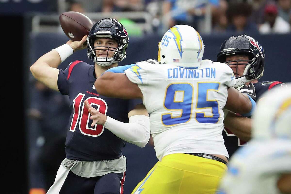 Houston Texans quarterback Davis Mills (10) passes over Los Angeles Chargers defensive end Christian Covington (95) during the third quarter of an NFL football game Sunday, Dec. 26, 2021 in Houston.