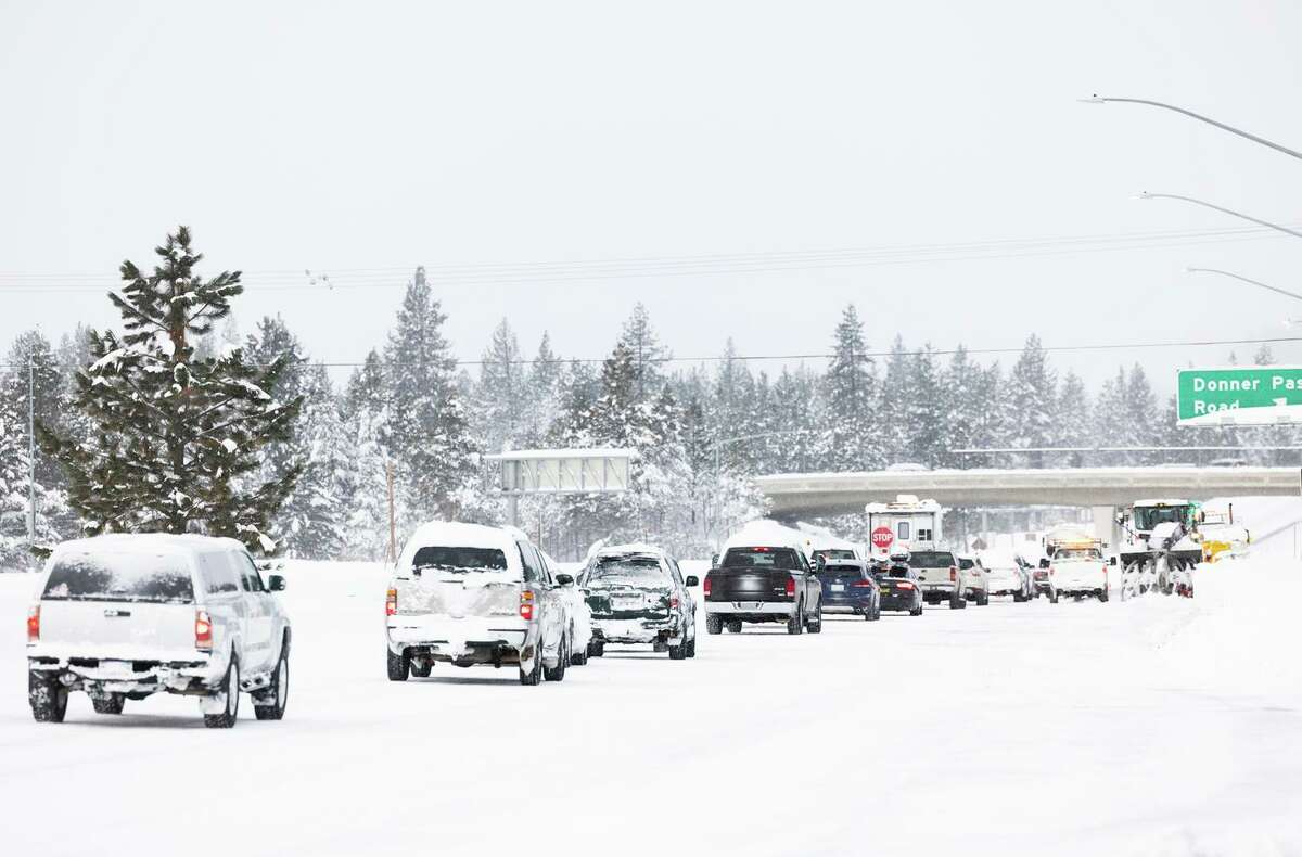 Vehicles wait in queue to be directed off the closed Interstate 80 in Truckee, Calif. on Dec. 28, 2021.