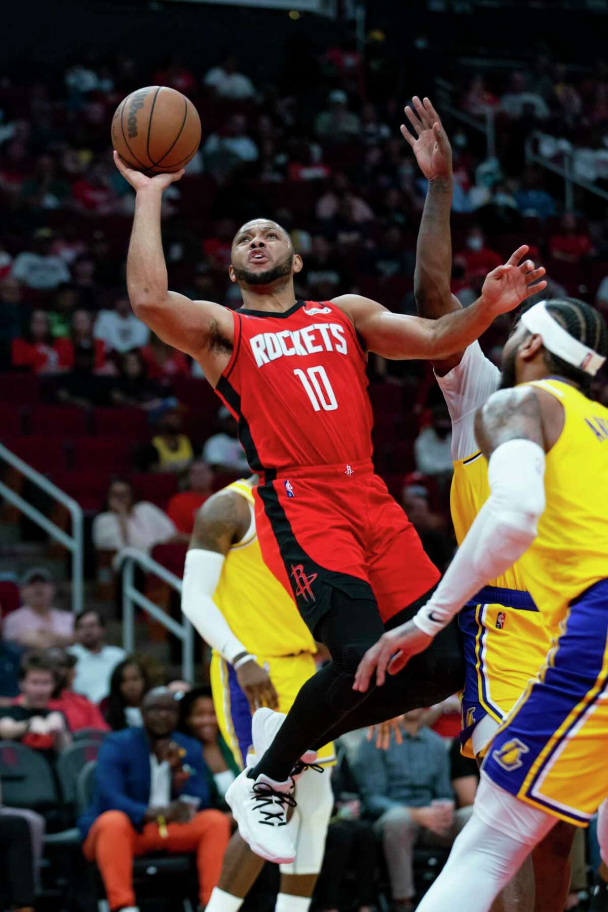 Houston Rockets guard Eric Gordon (10) shoots around Los Angeles Lakers forward Carmelo Anthony (7) during the first half of an NBA game between the Houston Rockets and Los Angeles Lakers on Tuesday, Dec. 28, 2021, at the Toyota Center in Houston.