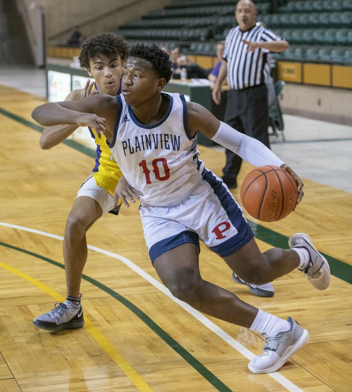 Plainview's Zaeq'won Riddley drives baseline past Midland High's Jalen Bracken 12/28/2021 during the Byron Johnston Holiday Classic tournament at the Chaparral Center. Tim Fischer/Reporter-Telegram