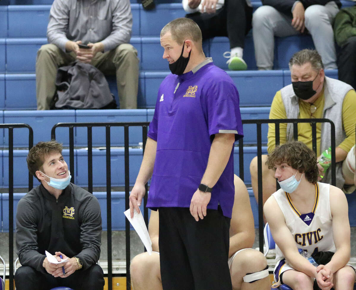 CM coach Andy Dreith (standing) shares a thought with assistant Caden Clark in the second quarter of the Eagles' win over Southwestern on Tuesday at the Columbia Tournament.