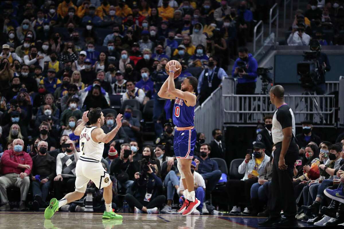 Golden State Warriors' Stephen Curry hits his career 3000th 3-pointer against Denver Nuggets' Facundo Campazzo in 3rd quarter during NBA game at Chase Center in San Francisco, Calif., on Tuesday, December 28, 2021.