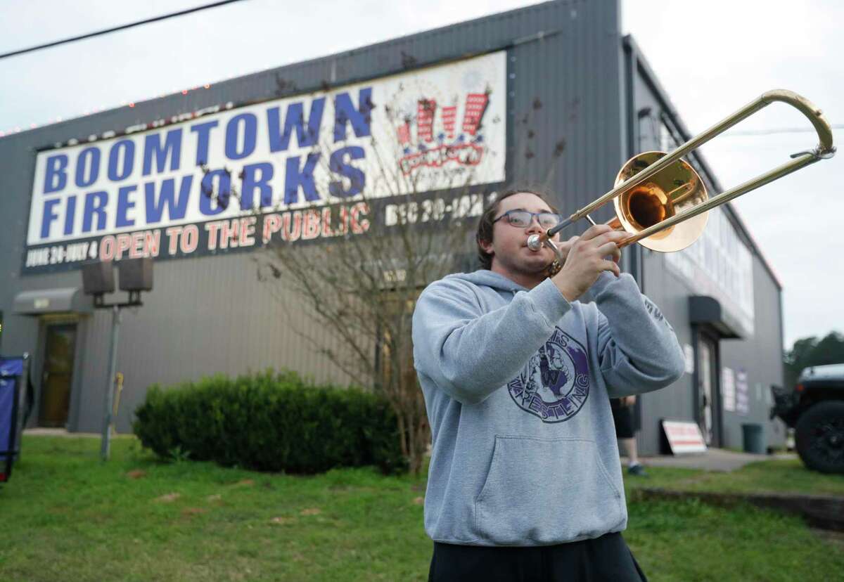 Willis High School band member Jeffery Blaker plays the trombone as he helps drum up business in front of Boomtown Fireworks along Highway 75 on Tuesday, Dec. 28, 2021, in Willis. The business, ran by Willis High School students and their families serve as a fund raiser for the high school’s band boosters and Operation Graduation.