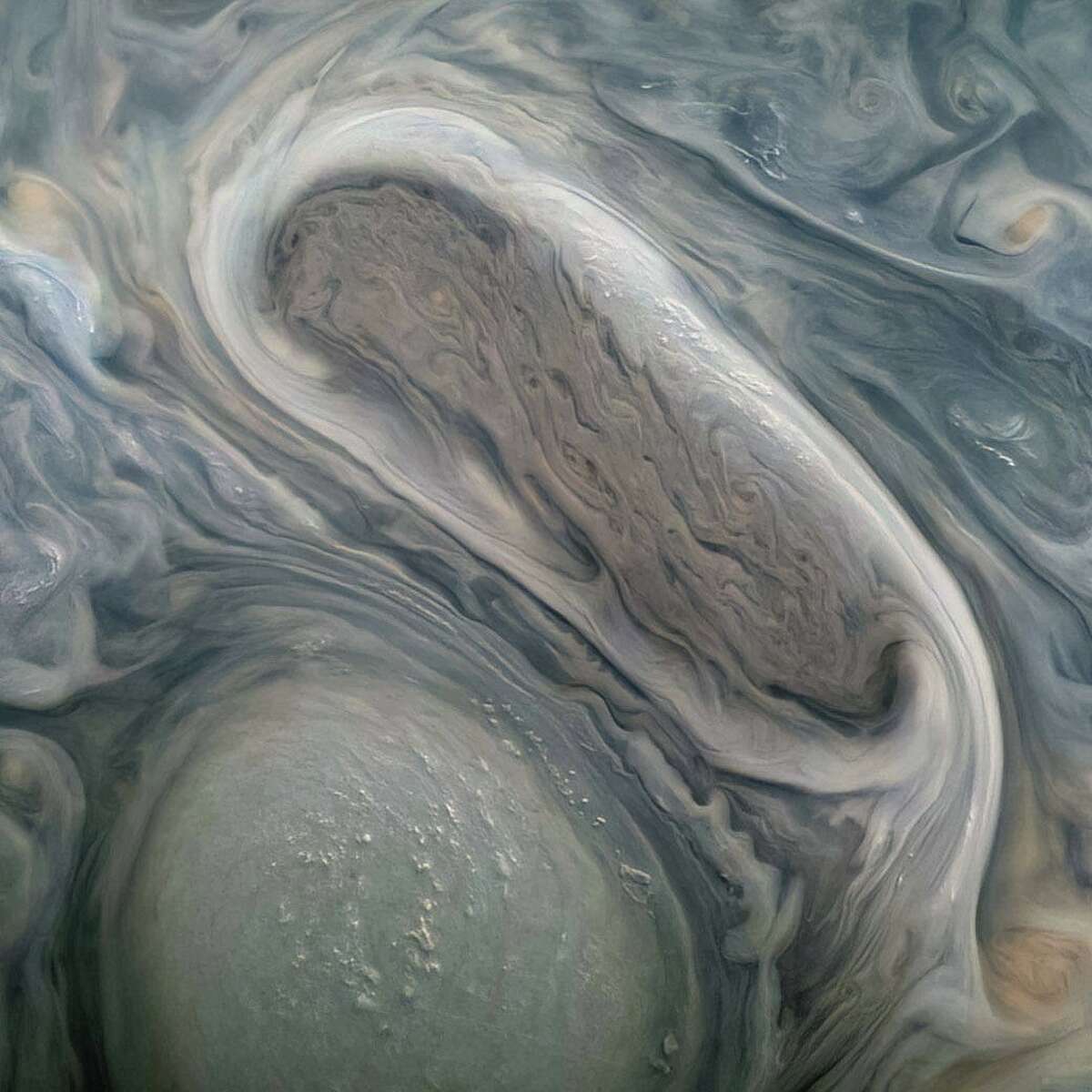 Juno capturó esta foto de dos tormentas en Júpiter cuando pasaba por el planeta en noviembre.  Según la NASA, el científico ciudadano Kevin M. Gill utilizó datos sin procesar de JunoCam para mejorar el color y el contraste.