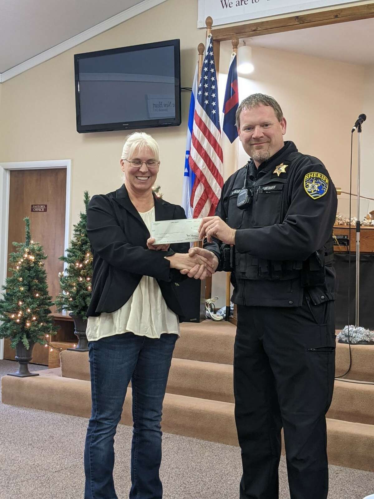 Lake County sheriff Rich Martin presents the Living Waters Fellowship Church with a check for $1,000 from the LCSO charitable campaign. The funds will go toward the purchase of a youth van.
