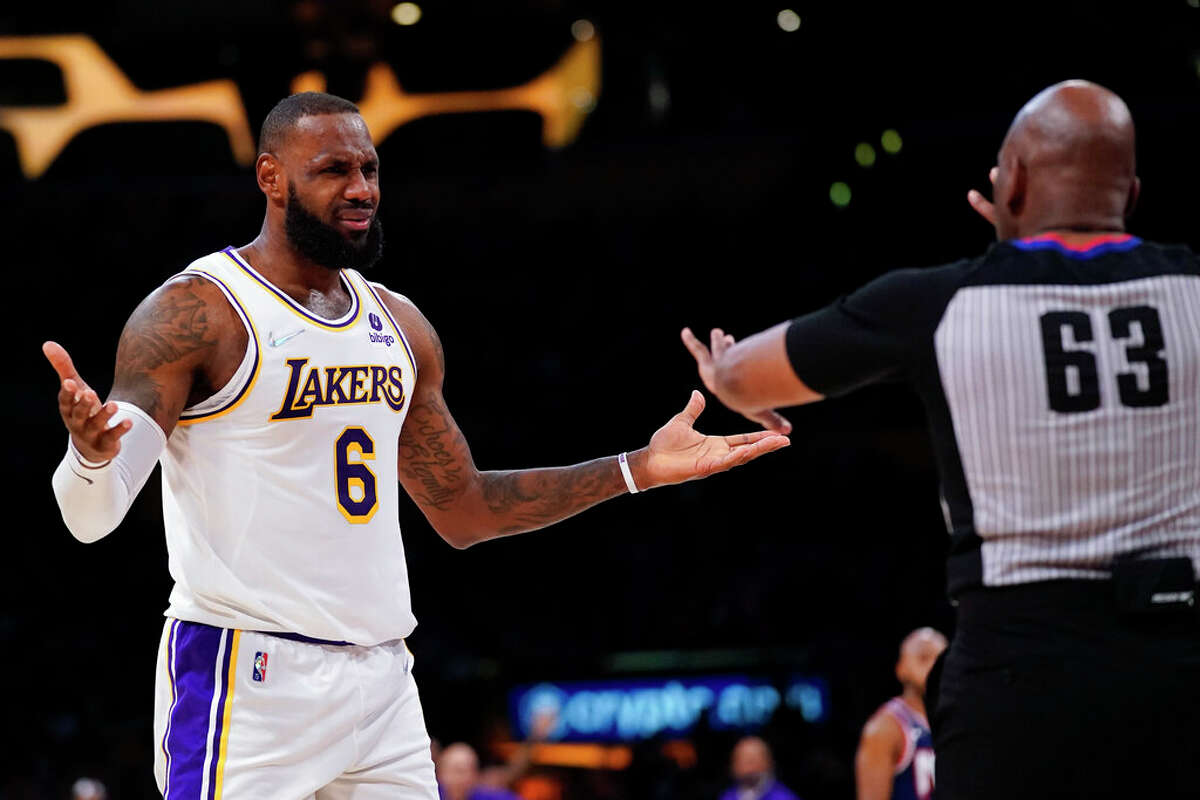 Los Angeles Lakers forward LeBron James disputes a call with referee Derek Richardson during the first half of an NBA basketball game in Los Angeles, Saturday, Dec. 25, 2021.