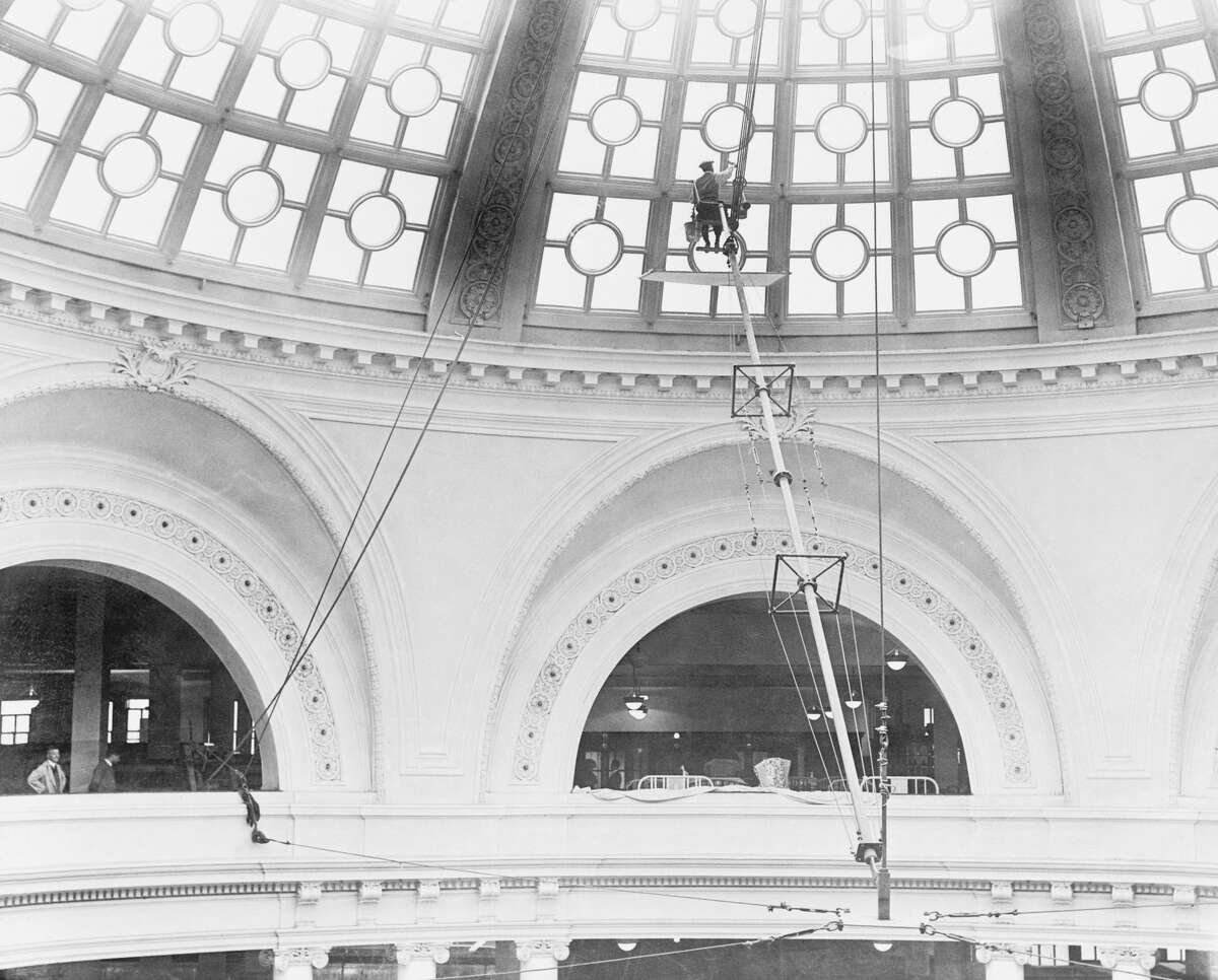 The worker at San Francisco's elegant The Emporium department store cleans the famed rotunda windows.