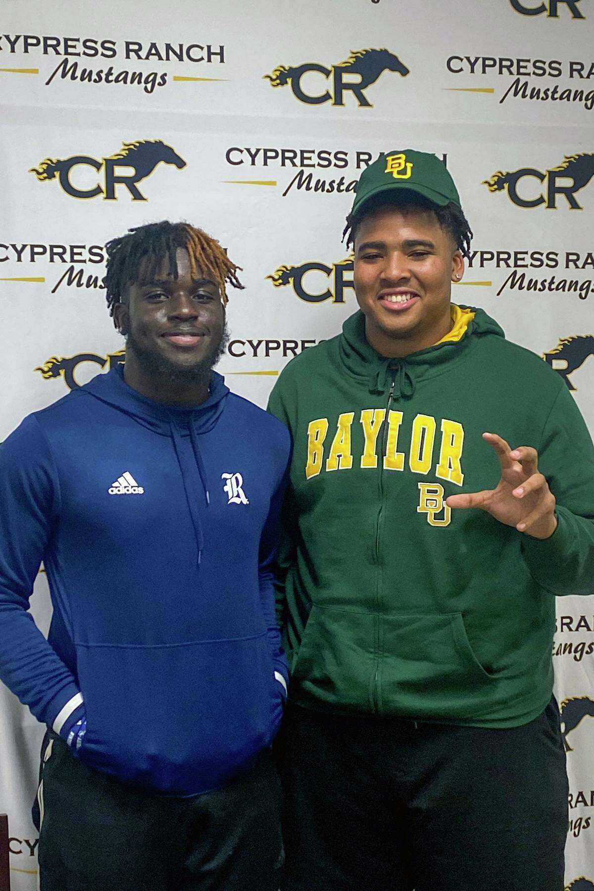 Cypress Ranch High School seniors Chibi Nwajuaku, left, and Bryce Simpson smile after signing their letters of intent to play college football on Dec. 15. Nwajuaku signed with Rice University and Simpson signed with Baylor University.