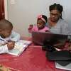 Damaris Skelton is seen with her daughter and son as she works from her home on Wednesday, Dec. 29, 2021 in Albany, N.Y.