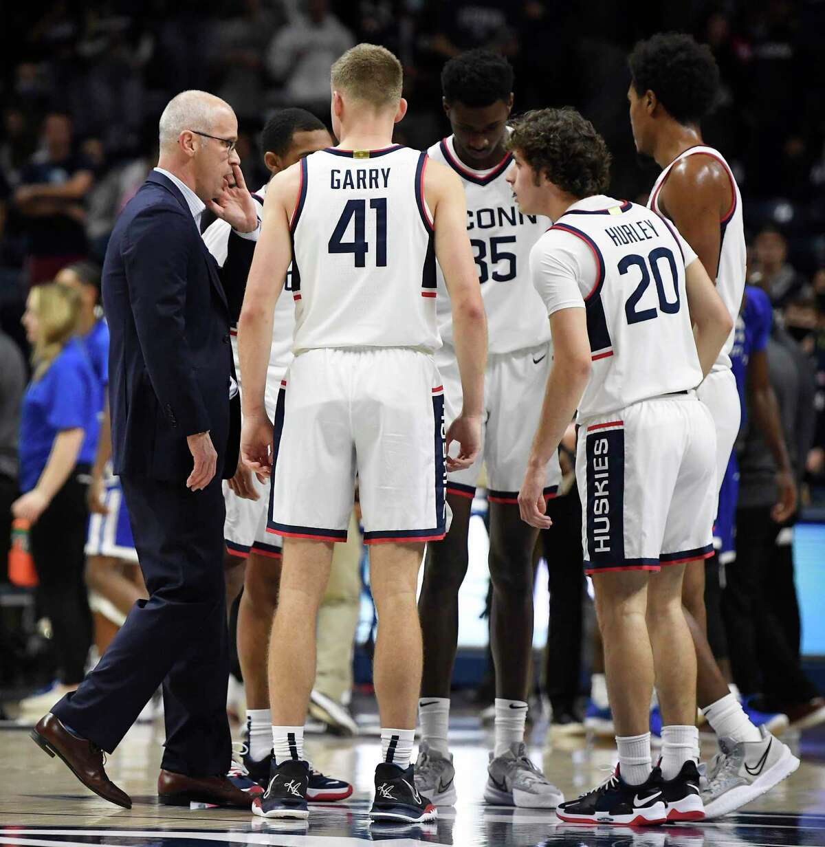 Connecticut head coach Dan Hurley, left, talks to players in a huddle including his son, Connecticut's Andrew Hurley (20) in the second half of an NCAA college basketball game, Tuesday, Nov. 9, 2021, in Storrs, Conn.
