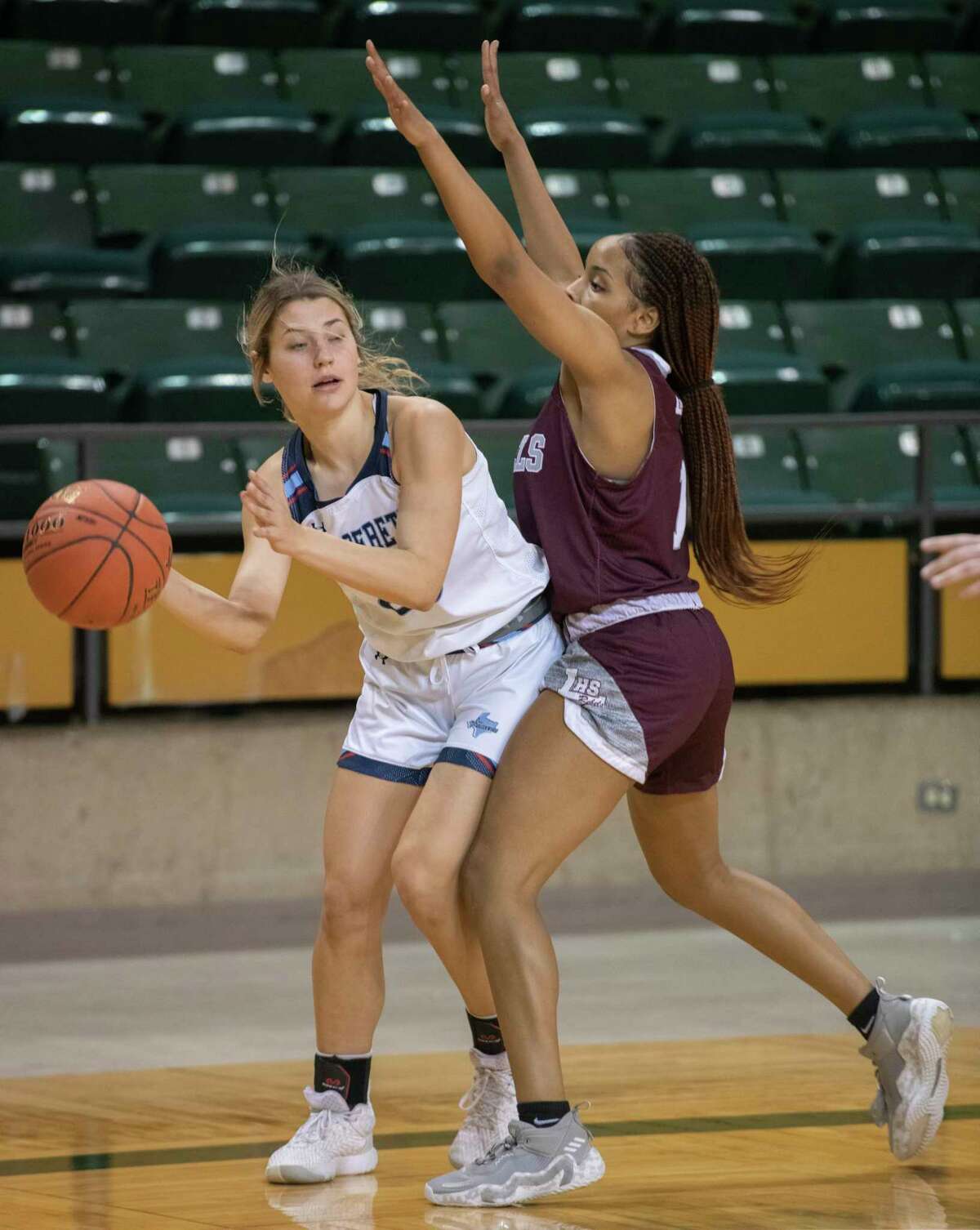 Greenwood's Kodi Hartman looks to pass around Legacy High's Myleah Young 12/29/2021 during the Byron Johnston Holiday Classic at the Chaparral Center. Tim Fischer/Reporter-Telegram